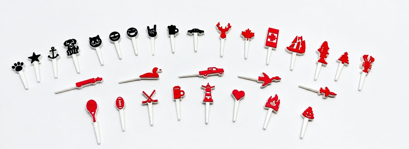 30 symbol cribbage pegs in black and red on white: paw, star, anchor, dog, cat, moose, maple leaf, lobster, Bluenose schooner, trout, Canada flag, Christmas tree, truck, loon, goose, jet, hockey sticks, lighthouse, heart and more